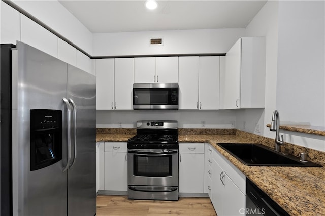 1801 E Katella Ave Unit 1091, Anaheim, CA 92805 - kitchen featuring appliances with stainless steel finishes, white cabinets, light wood-style floors, recessed lighting, and stone counters