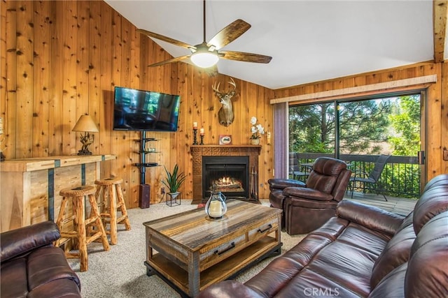 27657 Peninsula Dr, Lake Arrowhead, CA 92352 - living area with wooden walls, carpet, vaulted ceiling, a ceiling fan, and a warm lit fireplace