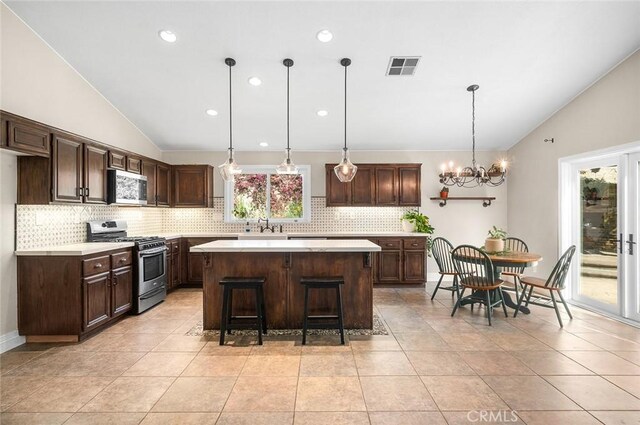 464 Appleby St, Corona, CA 92881 - kitchen featuring appliances with stainless steel finishes, vaulted ceiling, tasteful backsplash, light countertops, and recessed lighting