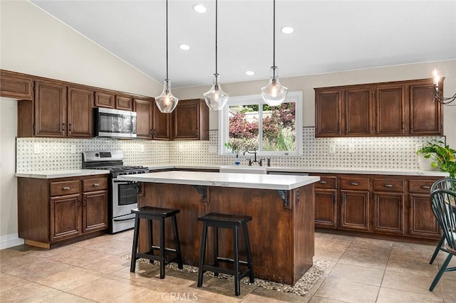 464 Appleby St, Corona, CA 92881 - kitchen featuring appliances with stainless steel finishes, decorative backsplash, light tile patterned flooring, a center island, and lofted ceiling