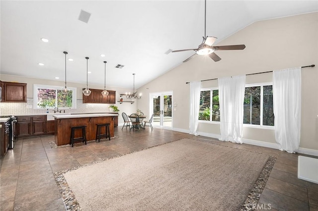 464 Appleby St, Corona, CA 92881 - kitchen featuring stainless steel range with gas stovetop, a center island, light countertops, a ceiling fan, and decorative backsplash