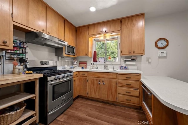 7100 Navajoa Ave, Atascadero, CA 93422 - kitchen featuring appliances with stainless steel finishes, under cabinet range hood, dark wood finished floors, light countertops, and brown cabinets