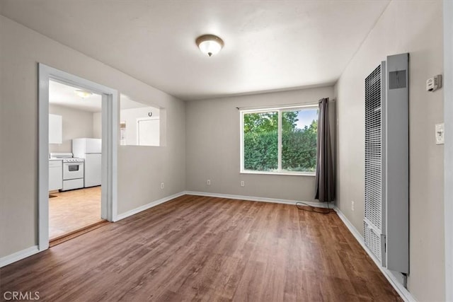 7100 Navajoa Ave, Atascadero, CA 93422 - unfurnished bedroom with a heating unit, freestanding refrigerator, and wood finished floors