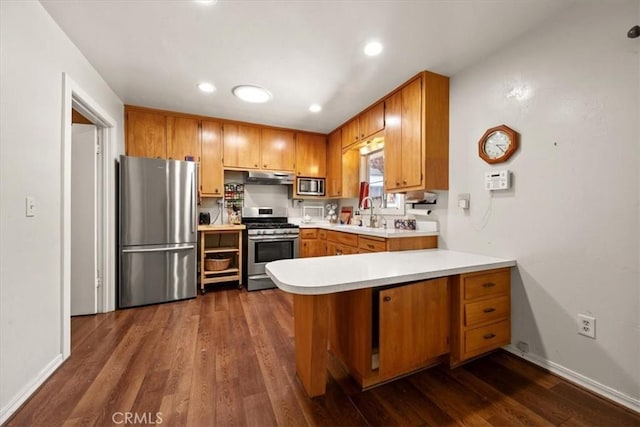 7100 Navajoa Ave, Atascadero, CA 93422 - kitchen with appliances with stainless steel finishes, a peninsula, light countertops, brown cabinetry, and recessed lighting