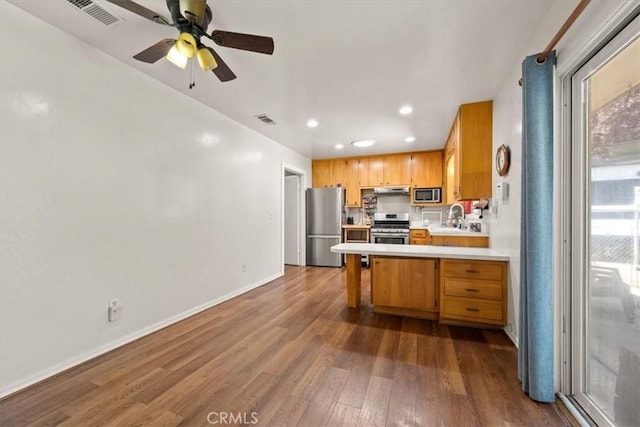 7100 Navajoa Ave, Atascadero, CA 93422 - kitchen with stainless steel appliances, light countertops, a peninsula, dark wood-style floors, and recessed lighting