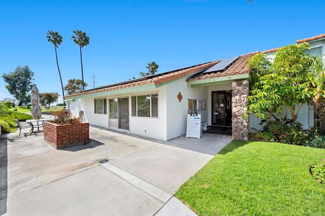 1866 Forestdale Dr, Encinitas, CA 92024 - view of front of house with roof mounted solar panels, a patio, a front lawn, and a tile roof