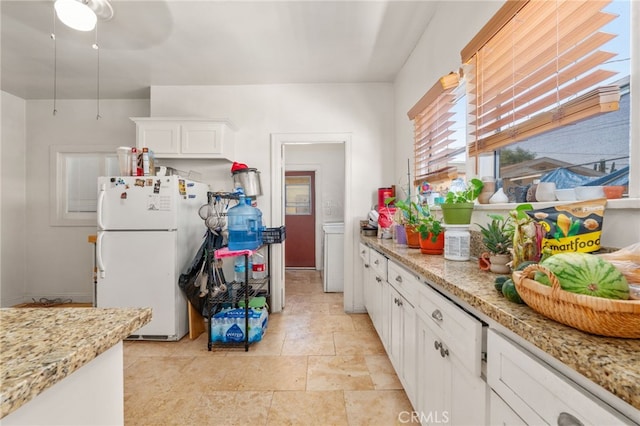 1026 Sentinel Ave, Los Angeles, CA 90063 - kitchen with freestanding refrigerator, white cabinetry, and light stone countertops