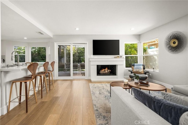 5 Bergamo, Irvine, CA 92614 - living room with plenty of natural light, a warm lit fireplace, light wood-type flooring, and recessed lighting