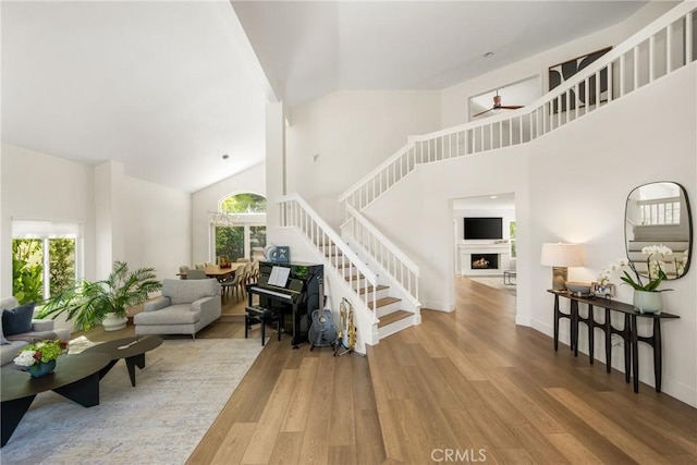 5 Bergamo, Irvine, CA 92614 - living area with high vaulted ceiling, wood finished floors, stairway, ceiling fan, and a lit fireplace