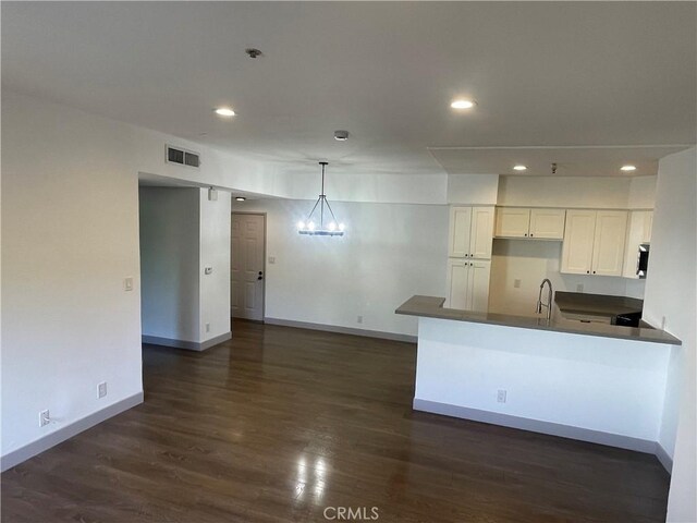 14914 Hamlin St Unit 105, Van Nuys, CA 91411 - kitchen featuring dark countertops, white cabinets, dark wood-style flooring, recessed lighting, and a peninsula