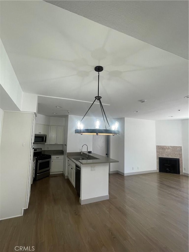 14914 Hamlin St Unit 105, Van Nuys, CA 91411 - kitchen featuring stainless steel appliances, a peninsula, dark wood-type flooring, white cabinets, and dark countertops