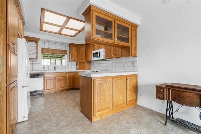 1851 Pacific Ave, Cayucos, CA 93430 - kitchen featuring white appliances, a peninsula, tasteful backsplash, glass insert cabinets, and crown molding