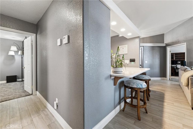 3312 Poplar St, Rosamond, CA 93560 - hallway with light wood-style flooring, a textured wall, and recessed lighting