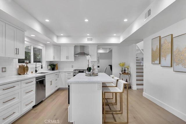 9500 Texhoma Ave, Northridge, CA 91325 - kitchen featuring wall chimney exhaust hood, stainless steel appliances, a center island, tasteful backsplash, and white cabinets