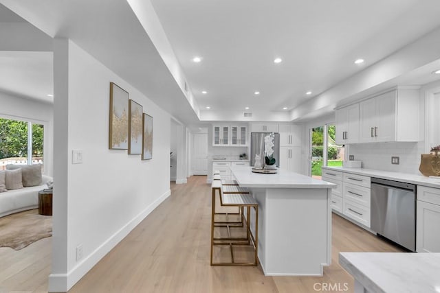 9500 Texhoma Ave, Northridge, CA 91325 - kitchen with dishwasher, white cabinets, light countertops, a breakfast bar, and recessed lighting