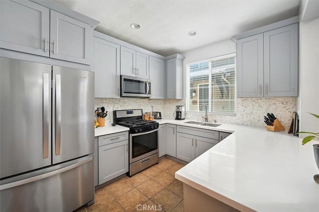 28440 Casselman Ln Unit 361, Saugus, CA 91350 - kitchen with stainless steel appliances, gray cabinetry, tasteful backsplash, light countertops, and light tile patterned flooring