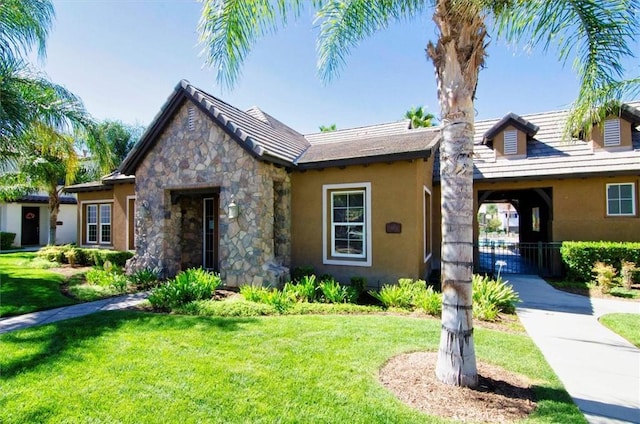28440 Casselman Ln Unit 361, Saugus, CA 91350 - view of front of property with a front yard, stucco siding, and stone siding
