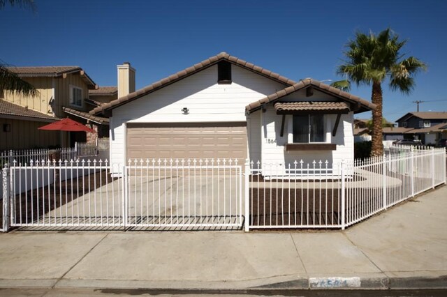 1564 Ashbury Way, Perris, CA 92571 - view of front of house featuring a tiled roof, an attached garage, a fenced front yard, and driveway