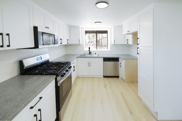 1564 Ashbury Way, Perris, CA 92571 - kitchen with stainless steel appliances, light wood-style floors, white cabinets, and tasteful backsplash
