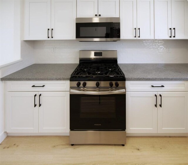 1564 Ashbury Way, Perris, CA 92571 - kitchen featuring appliances with stainless steel finishes, white cabinets, tasteful backsplash, and light wood-type flooring