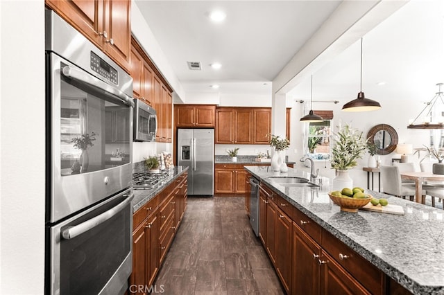 11810 Sanderling Way, Jurupa Valley, CA 91752 - kitchen with appliances with stainless steel finishes, dark stone countertops, brown cabinets, recessed lighting, and decorative light fixtures