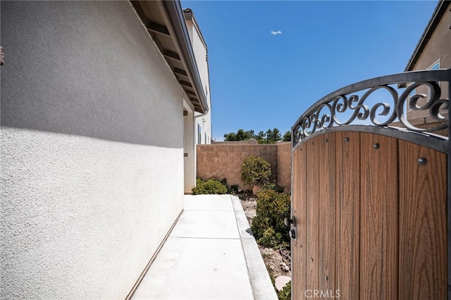 11810 Sanderling Way, Jurupa Valley, CA 91752 - view of side of home featuring stucco siding and a gate