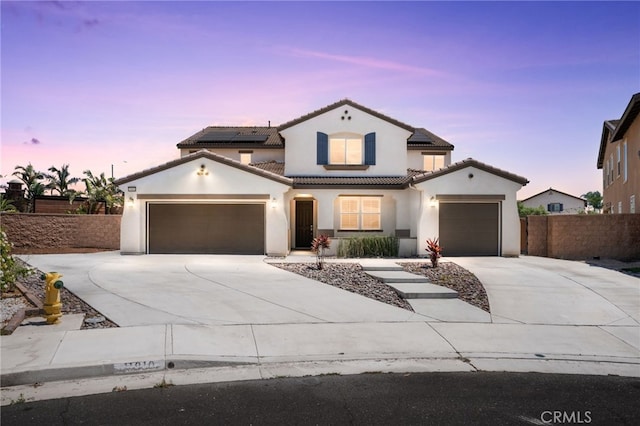 11810 Sanderling Way, Jurupa Valley, CA 91752 - mediterranean / spanish home with concrete driveway, stucco siding, a tile roof, an attached garage, and roof mounted solar panels