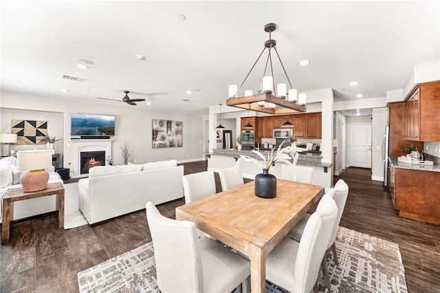 11810 Sanderling Way, Jurupa Valley, CA 91752 - dining room featuring ceiling fan, dark wood finished floors, recessed lighting, and a warm lit fireplace