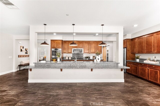 11810 Sanderling Way, Jurupa Valley, CA 91752 - kitchen featuring stainless steel appliances, a breakfast bar area, a spacious island, stone countertops, and recessed lighting