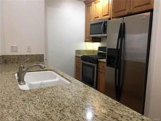 2750 Artesia Blvd Unit 341, Redondo Beach, CA 90278 - kitchen featuring stainless steel appliances, light stone countertops, and brown cabinetry