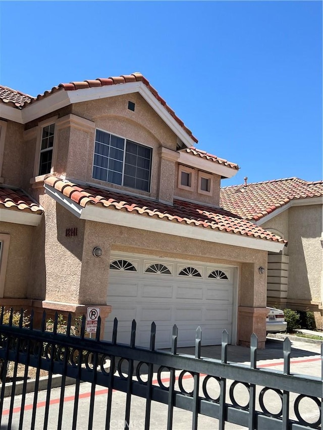 12143 Ferris Rd, El Monte, CA 91732 - view of front facade featuring a tiled roof, stucco siding, and a garage
