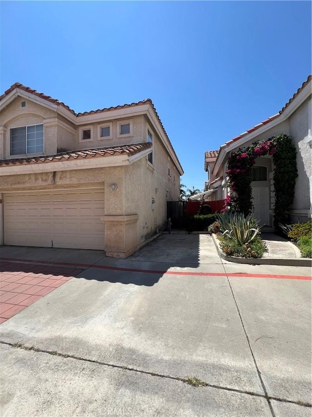 12143 Ferris Rd, El Monte, CA 91732 - view of side of home featuring a tile roof, stucco siding, and driveway