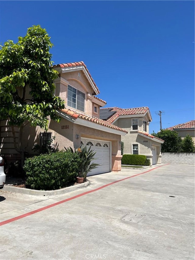 12143 Ferris Rd, El Monte, CA 91732 - mediterranean / spanish-style house with a tiled roof, stucco siding, and driveway