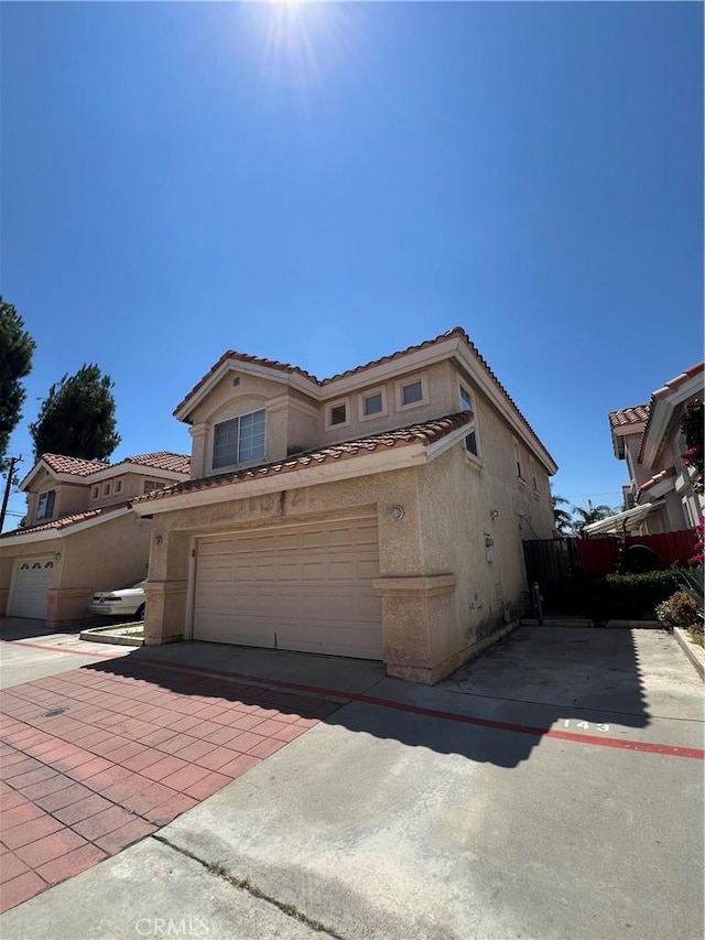 12143 Ferris Rd, El Monte, CA 91732 - view of front of home featuring stucco siding, a tile roof, decorative driveway, and an attached garage