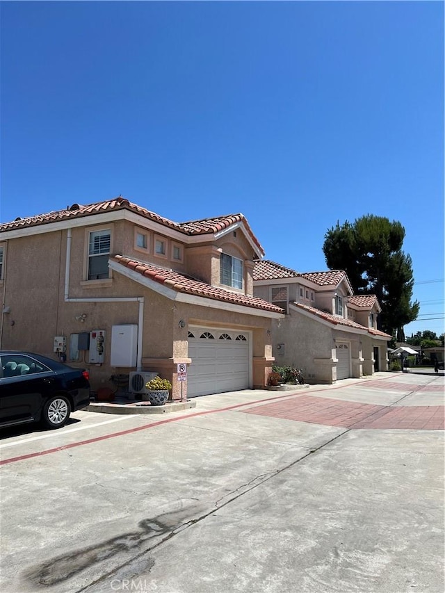 12143 Ferris Rd, El Monte, CA 91732 - view of front of house featuring a garage, concrete driveway, stucco siding, and a tiled roof