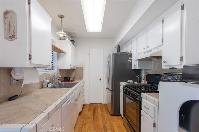 123 Olive St, Paso Robles, CA 93446 - kitchen featuring under cabinet range hood, gas stove, tile counters, white dishwasher, and white cabinetry