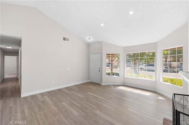 37537 Sabal Ct, Palmdale, CA 93552 - unfurnished living room featuring lofted ceiling, wood finished floors, recessed lighting, and a textured ceiling