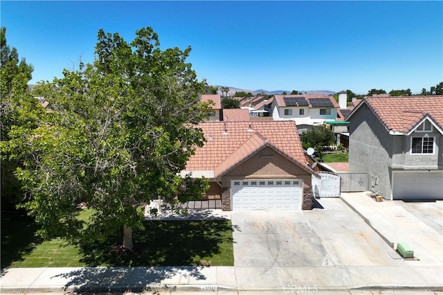37537 Sabal Ct, Palmdale, CA 93552 - view of front of house with a tile roof, a gate, driveway, and stucco siding