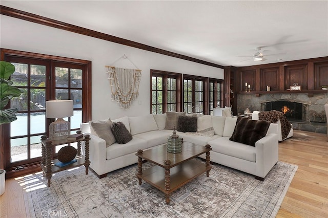 6137 Paseo La Vis, Woodland Hills, CA 91367 - living area with a stone fireplace, ornamental molding, light wood-style floors, and ceiling fan