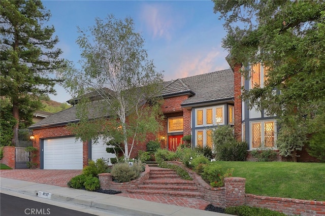 6137 Paseo La Vis, Woodland Hills, CA 91367 - view of front of home with brick siding, a lawn, decorative driveway, and a garage