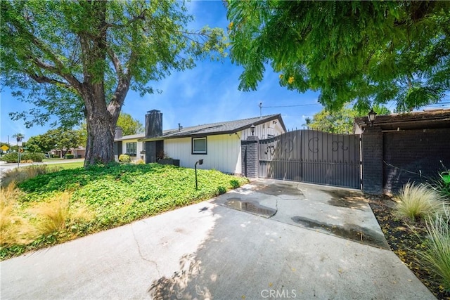 780 S Briargate Ln, Covina, CA 91723 - rear view of house featuring a gate, a chimney, driveway, and brick siding