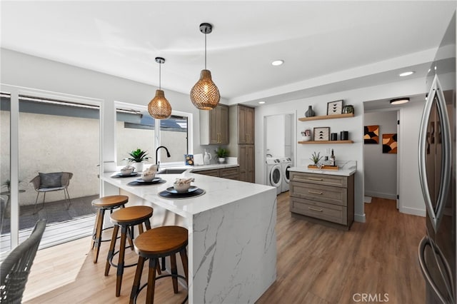 41442 Avenida De La Reina, Temecula, CA 92592 - kitchen with washer and clothes dryer, open shelves, a breakfast bar area, light wood-style floors, and recessed lighting
