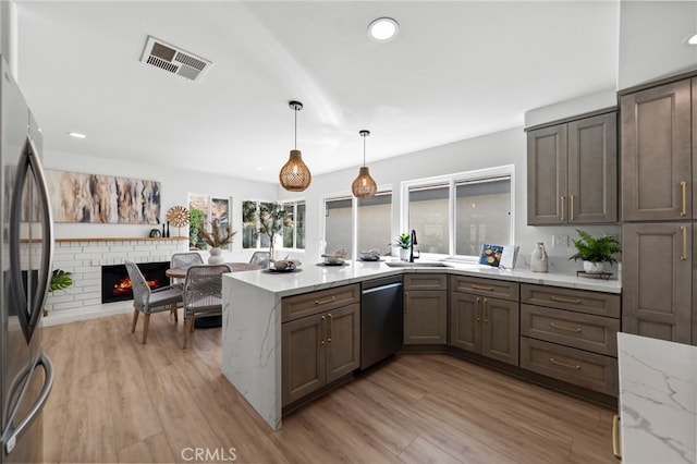 41442 Avenida De La Reina, Temecula, CA 92592 - kitchen with appliances with stainless steel finishes, a peninsula, light wood finished floors, light stone countertops, and pendant lighting