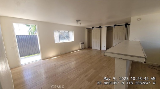 805 S Crane Ave, Compton, CA 90221 - unfurnished bedroom featuring a barn door, light wood-type flooring, and access to exterior