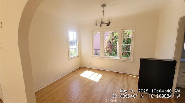 805 S Crane Ave, Compton, CA 90221 - unfurnished dining area with arched walkways, wood finished floors, and a chandelier