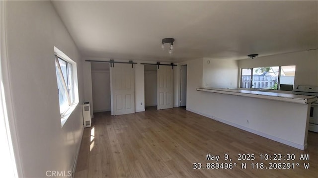 805 S Crane Ave, Compton, CA 90221 - unfurnished bedroom with a barn door and light wood finished floors