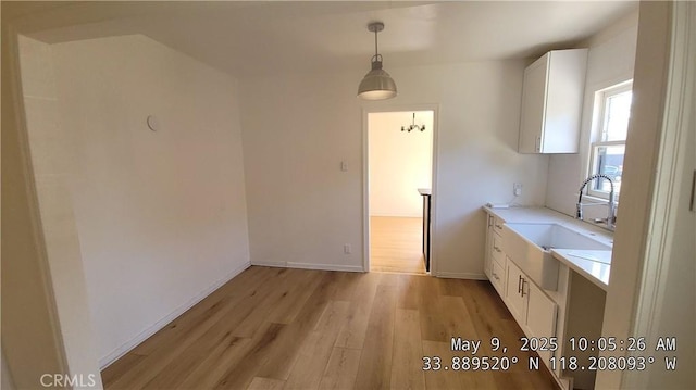 805 S Crane Ave, Compton, CA 90221 - kitchen with light wood-style floors, white cabinetry, light countertops, and decorative light fixtures