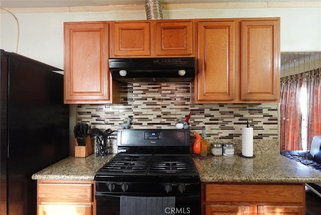 1063 Quarry St, Corona, CA 92879 - kitchen with black appliances, under cabinet range hood, tasteful backsplash, and light stone countertops
