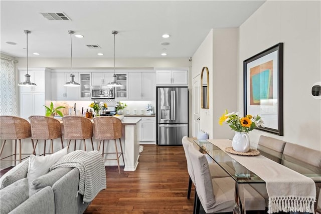 22088 Barrington Way, Saugus, CA 91350 - kitchen featuring stainless steel appliances, glass insert cabinets, dark wood-style flooring, a kitchen breakfast bar, and white cabinets