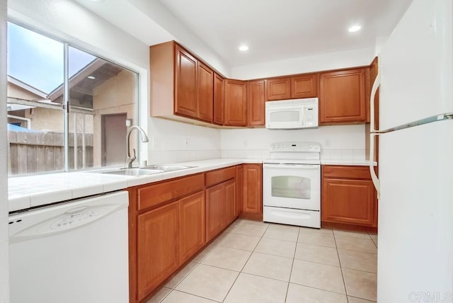 3694 Branch Ct, Oceanside, CA 92058 - kitchen featuring white appliances, tile counters, light tile patterned flooring, brown cabinetry, and recessed lighting